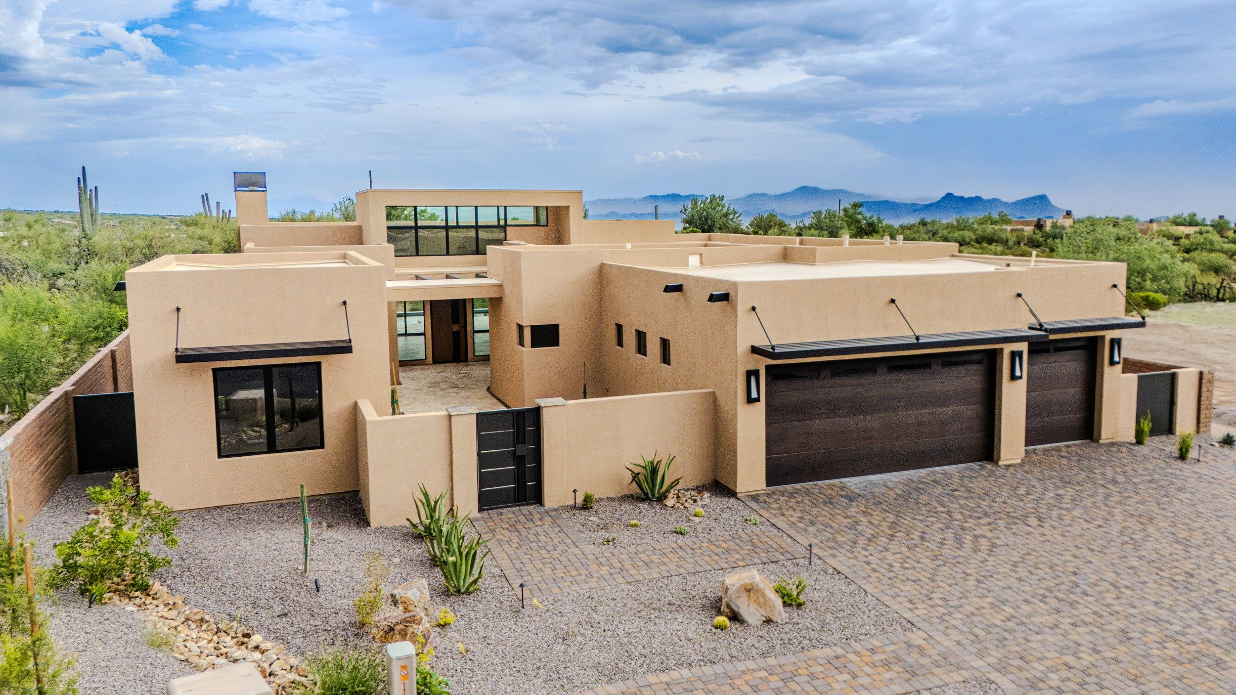 Aerial of the home and desert lot with the Tortolita Mountains beyond