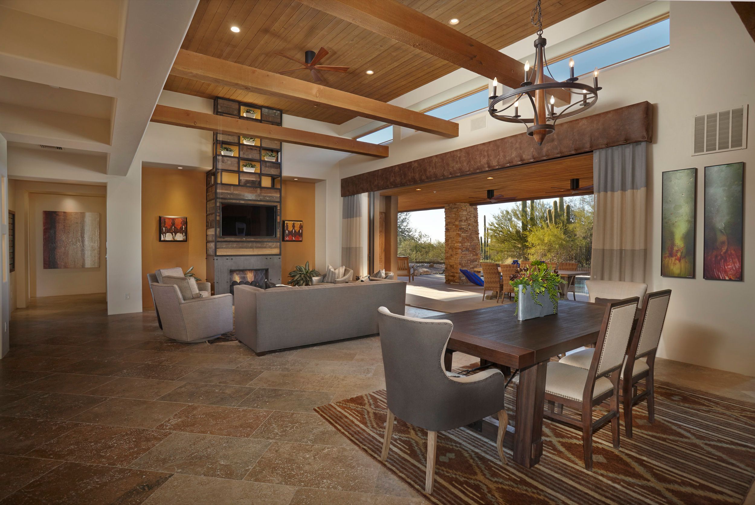 Great room and dining area with a beamed ceiling and pocketing glass to the desert