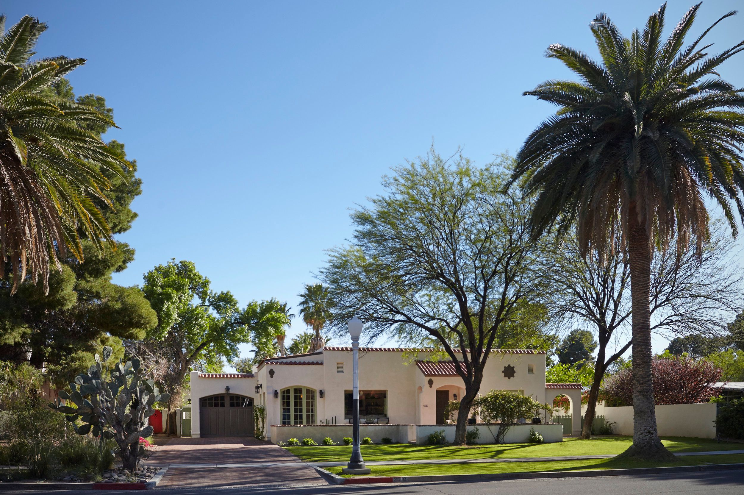 Spanish colonial revival home with a tiled roof, palms and street frontage in Sam Hughes