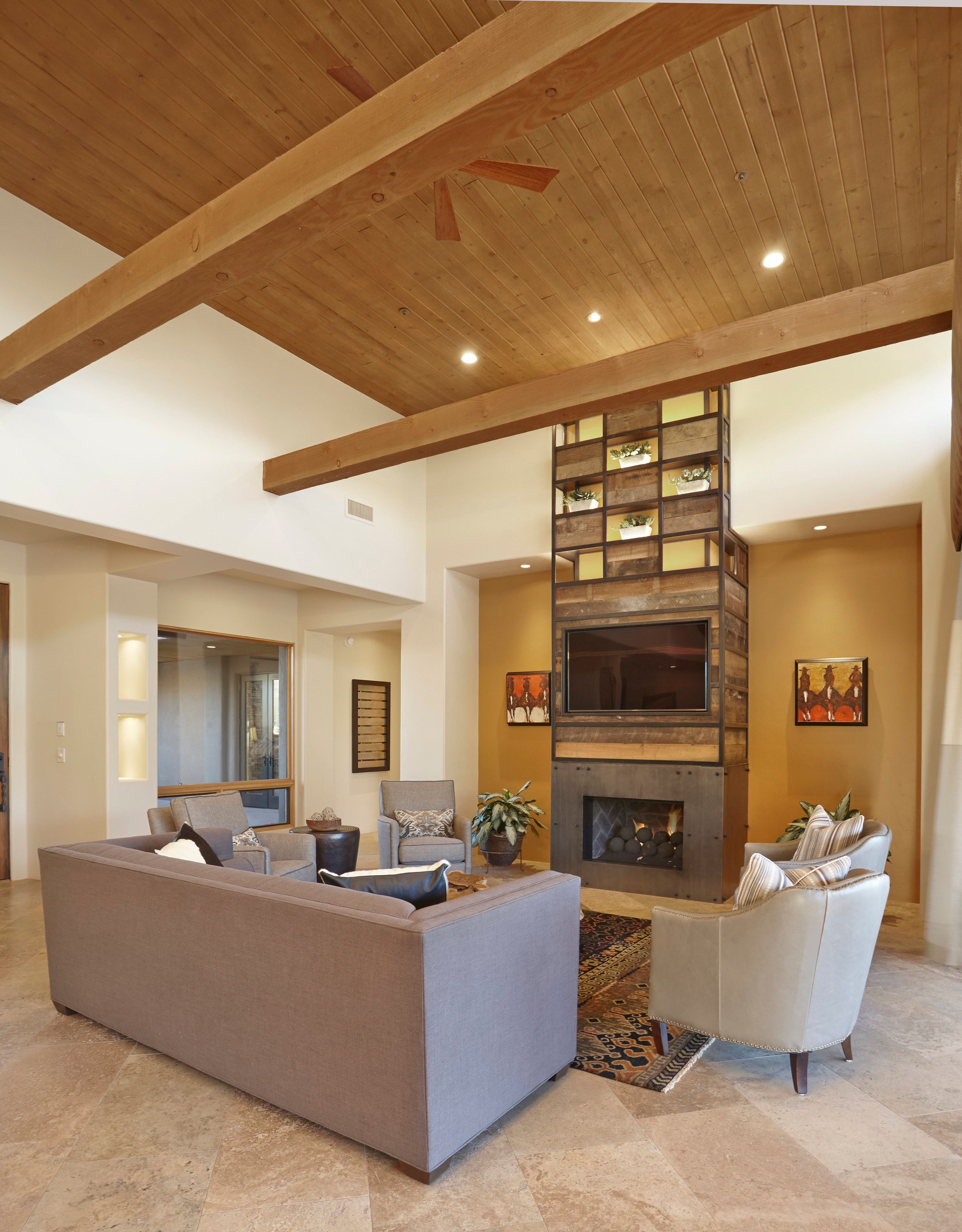 Living room with a stone fireplace, vaulted wood ceiling and sectional seating