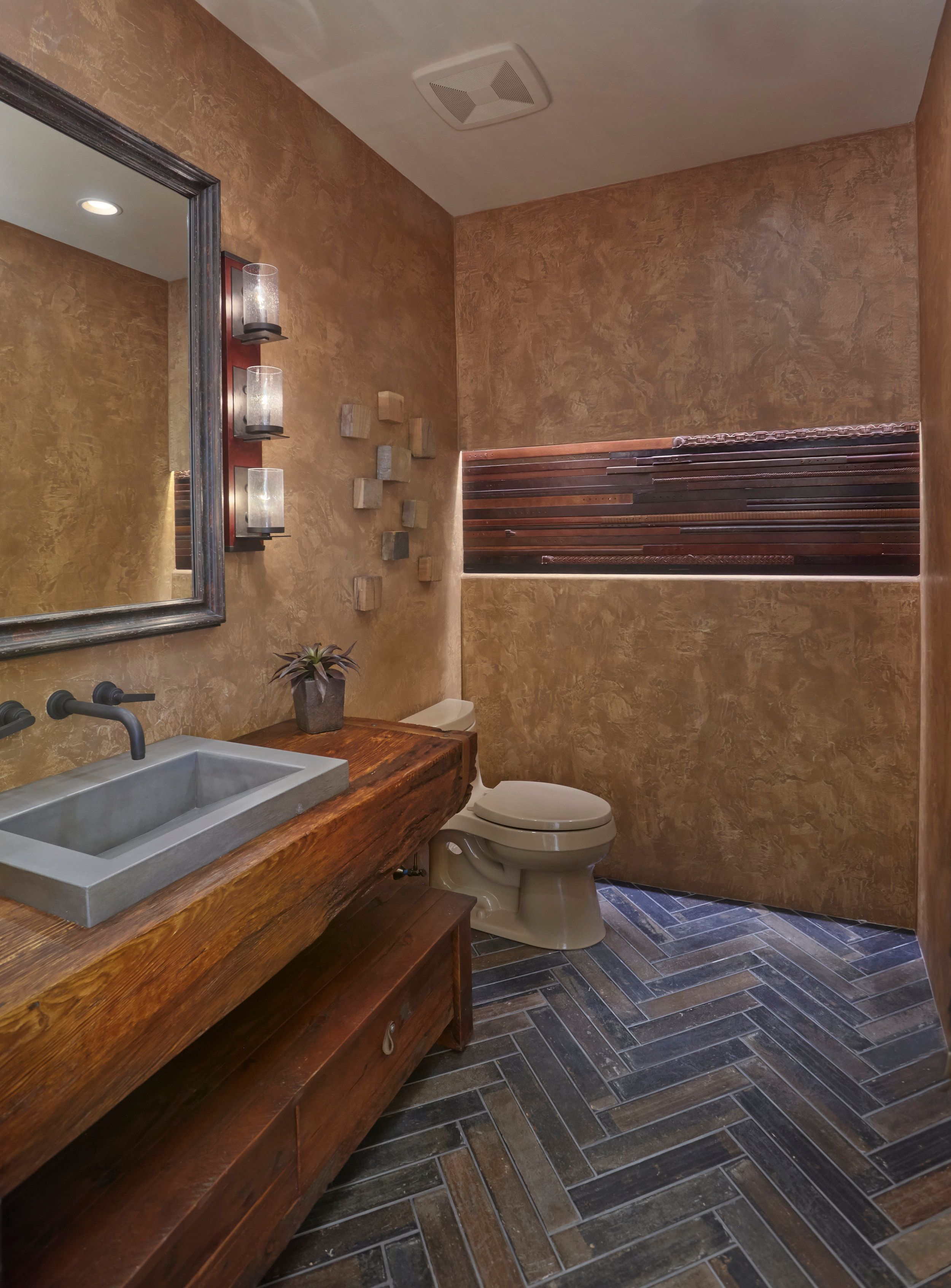 Powder room with a plaster wall, timber vanity and herringbone tile floor