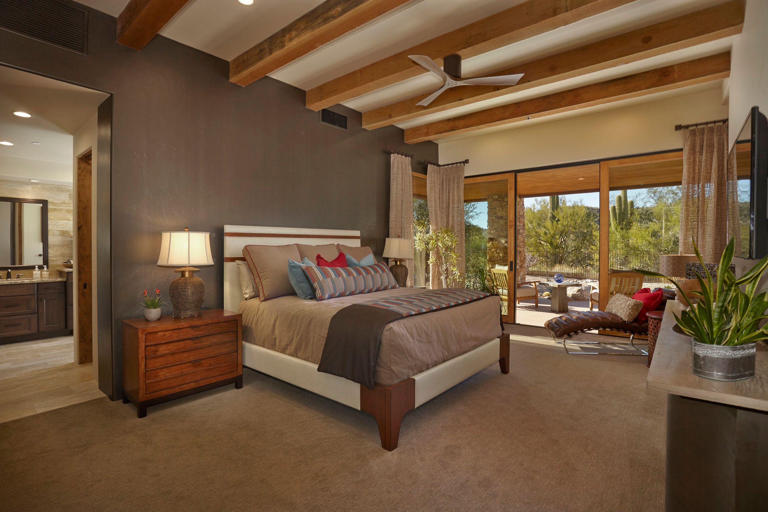 Primary bedroom with a beamed ceiling and sliding doors onto the patio