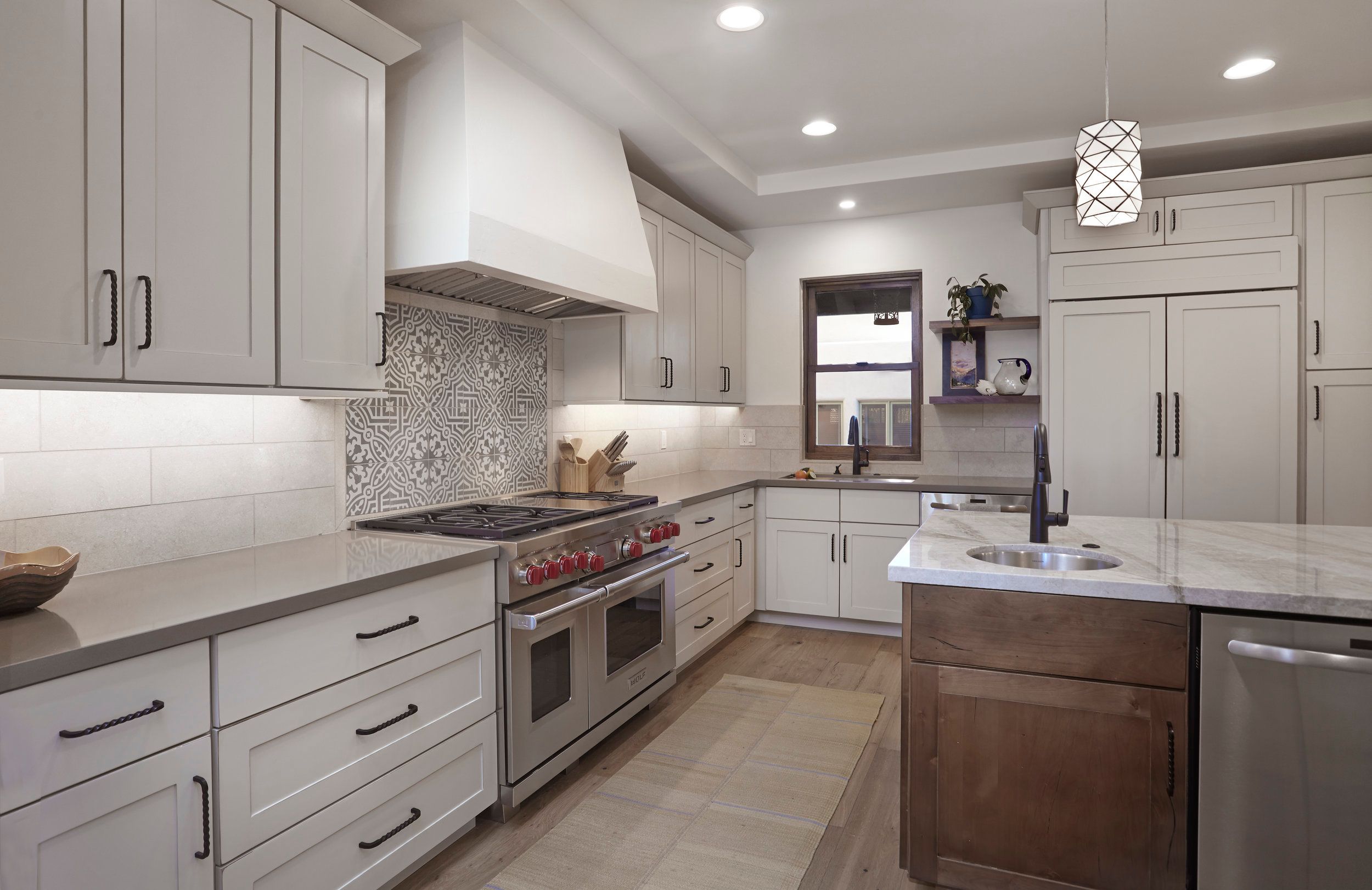 Kitchen with a professional range, patterned tile backsplash and walnut island
