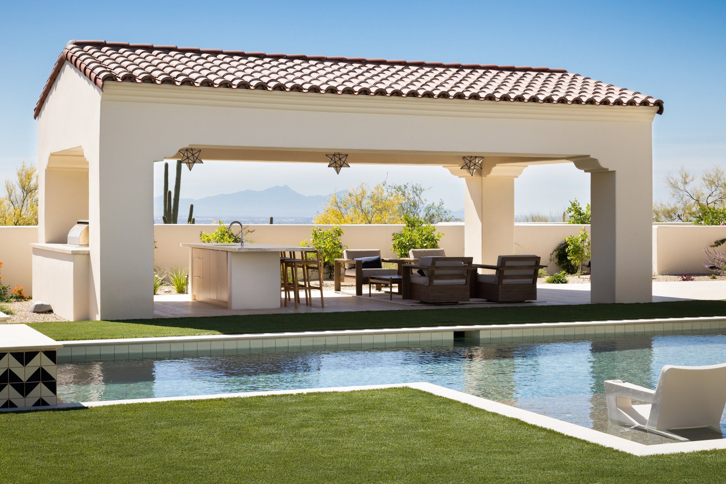 Poolside ramada with an outdoor kitchen and dining, mountains beyond