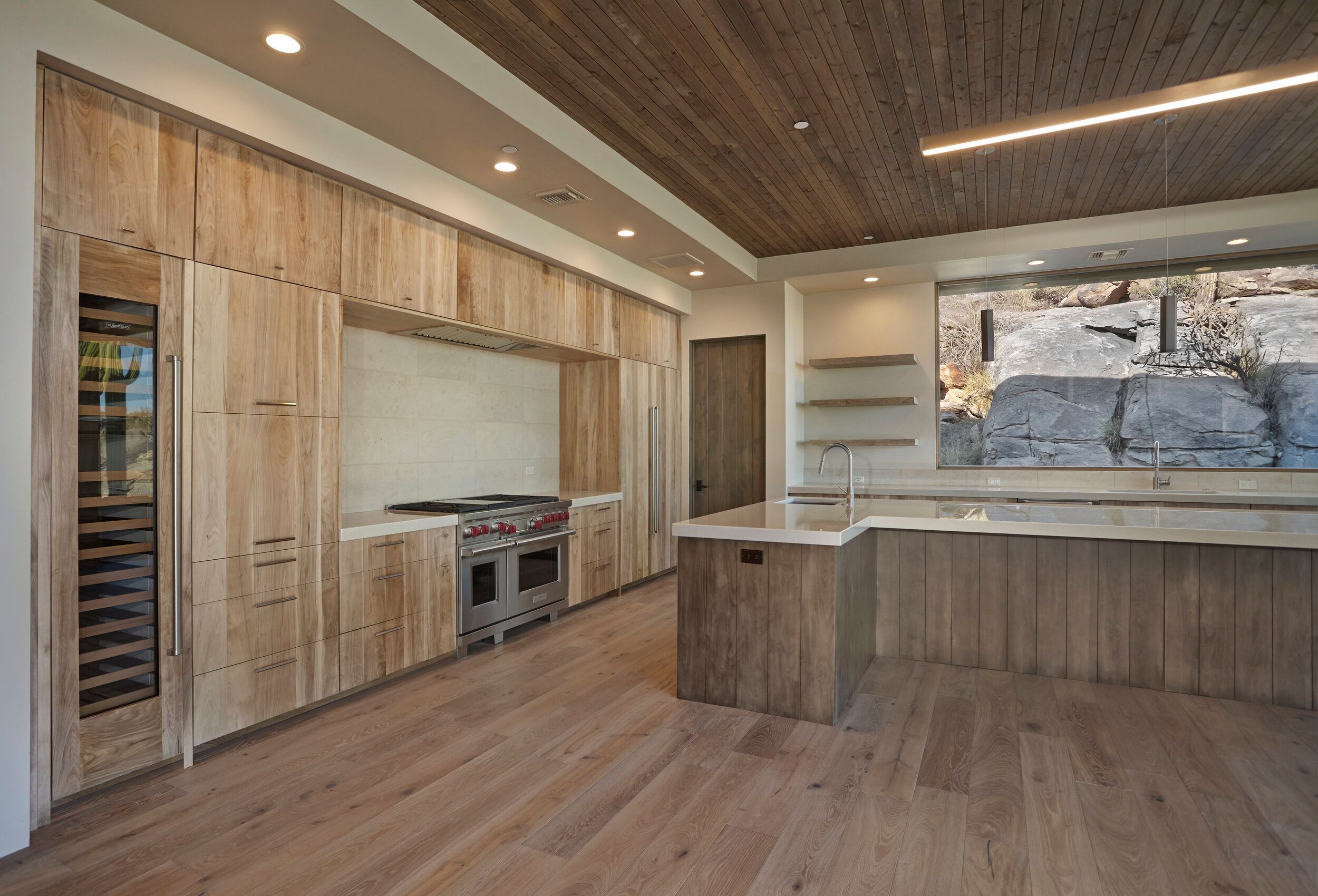 Kitchen with rift oak cabinetry, wine refrigerator and a boulder view window