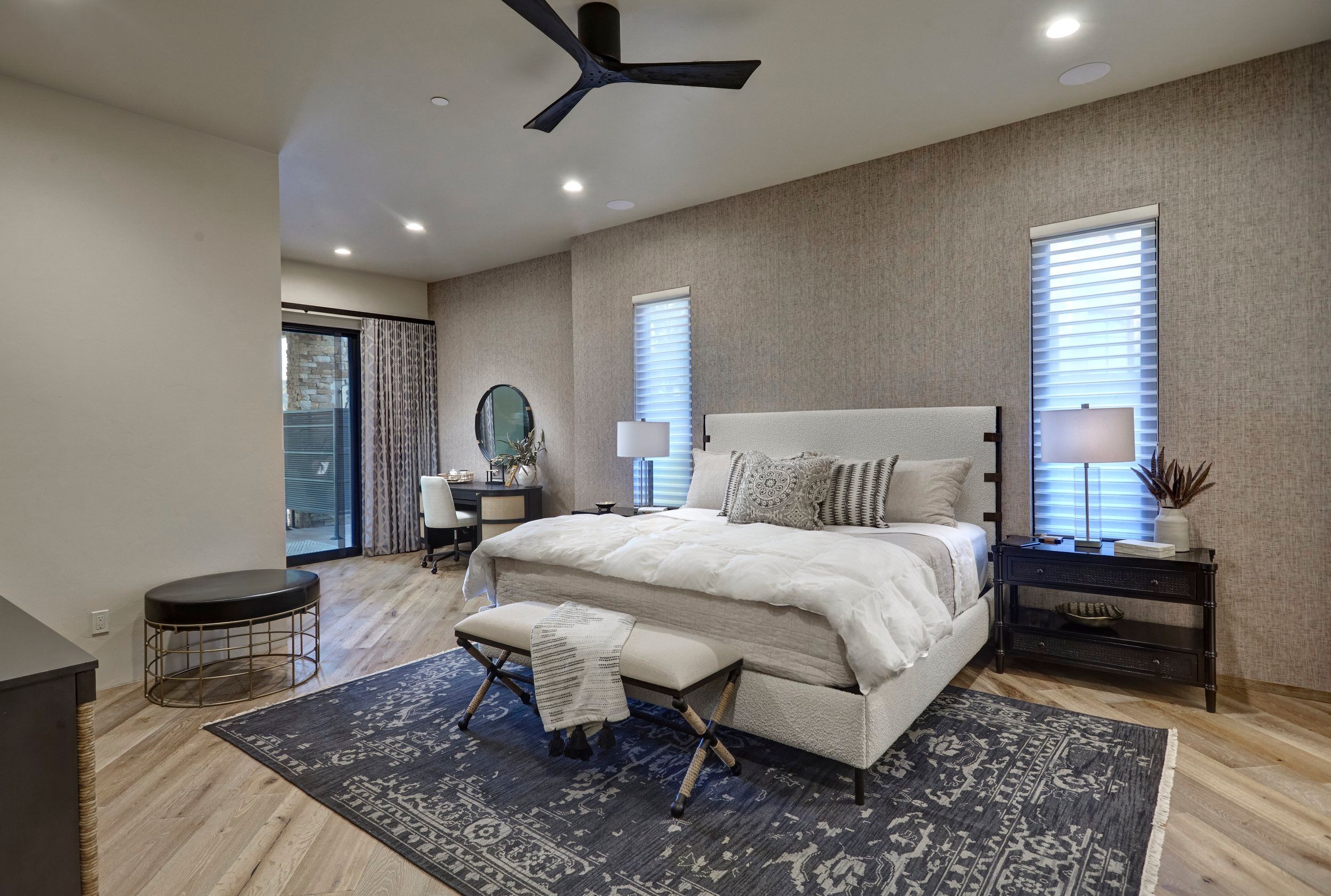 Primary bedroom with an upholstered bed, grasscloth wall and patio doors