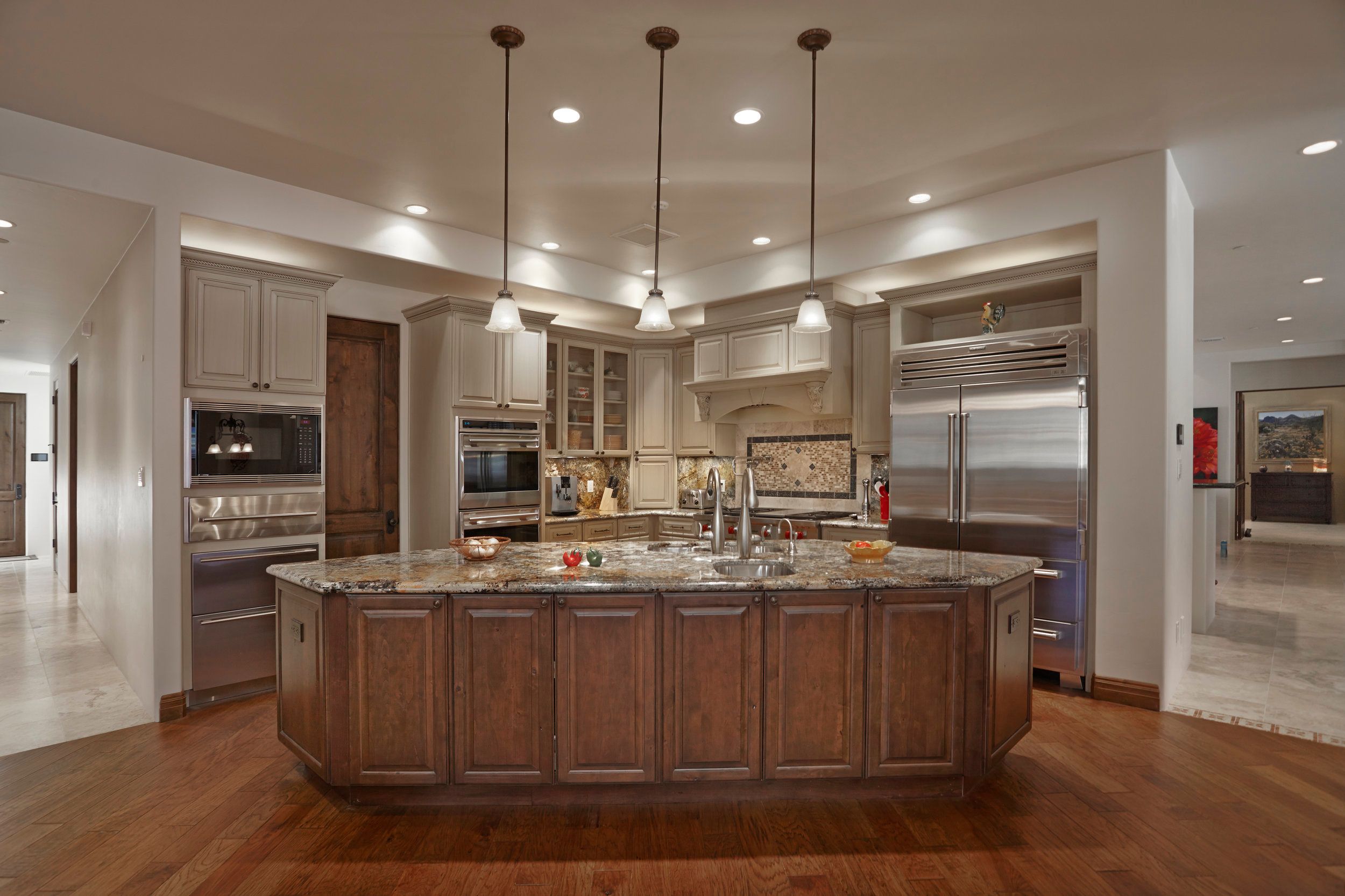 Kitchen with a large granite island, pendant lights and stainless appliances