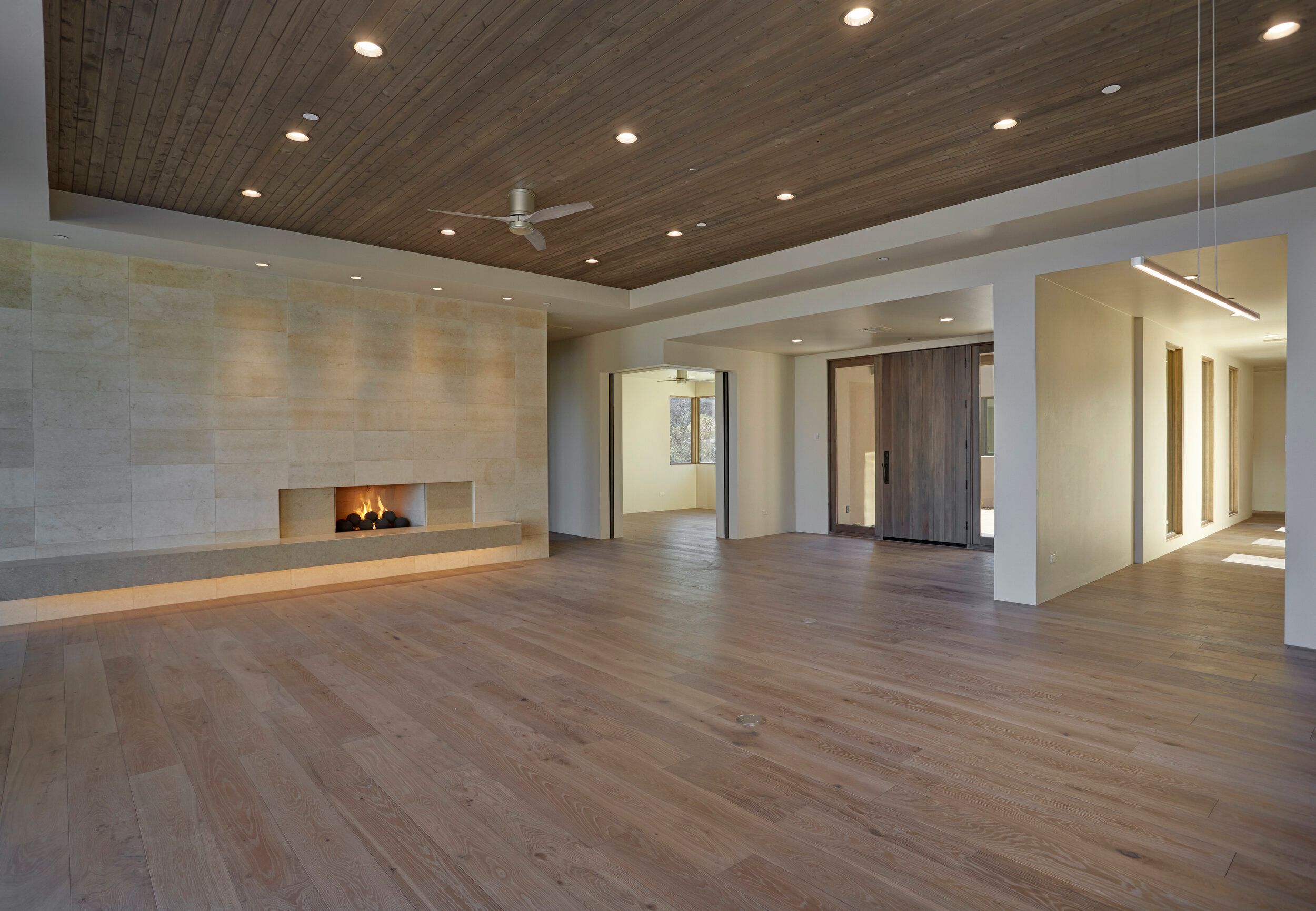 Living room with a linear fireplace set into a plaster wall
