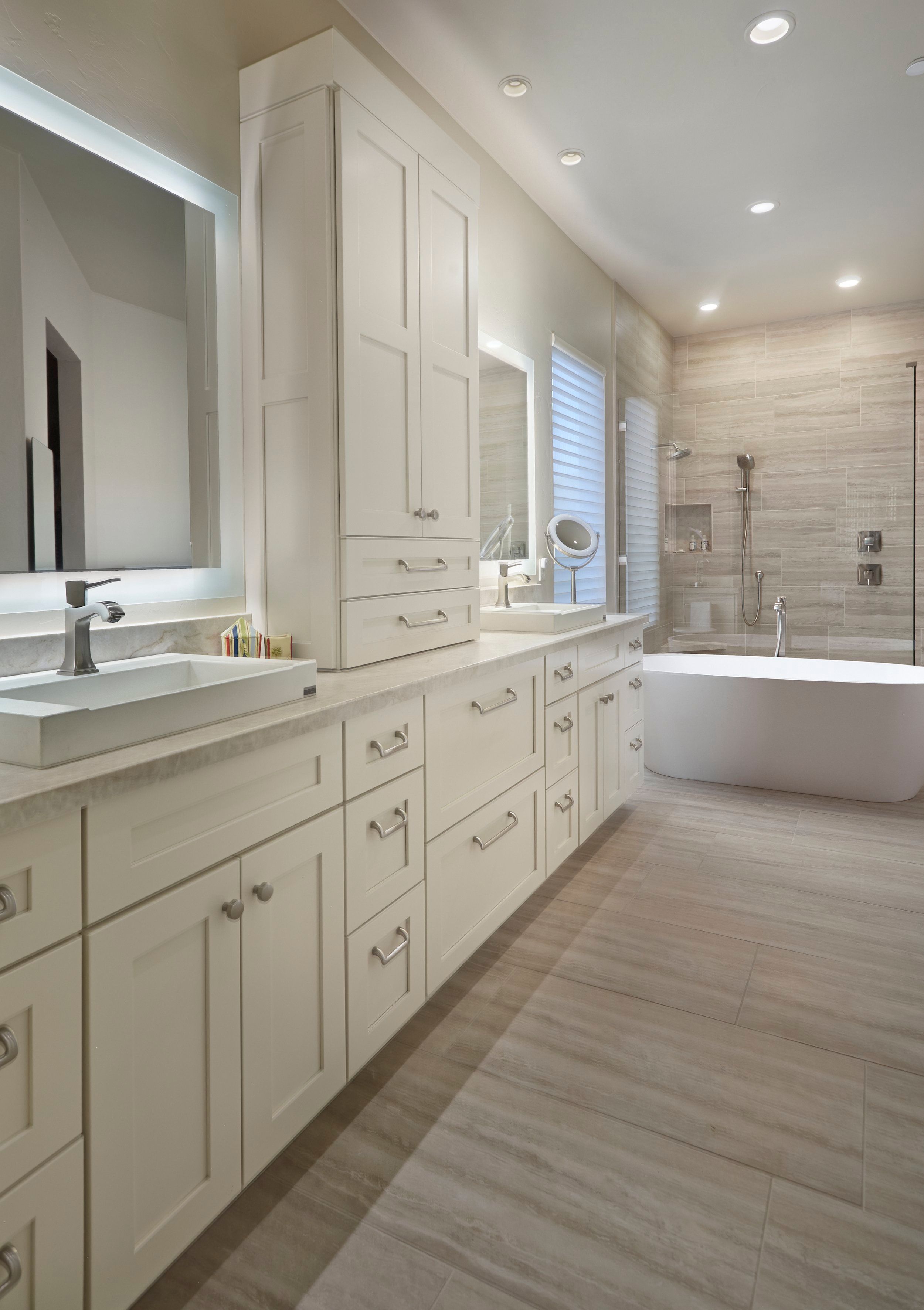 Primary bathroom with a long white vanity, freestanding tub and walk-in shower