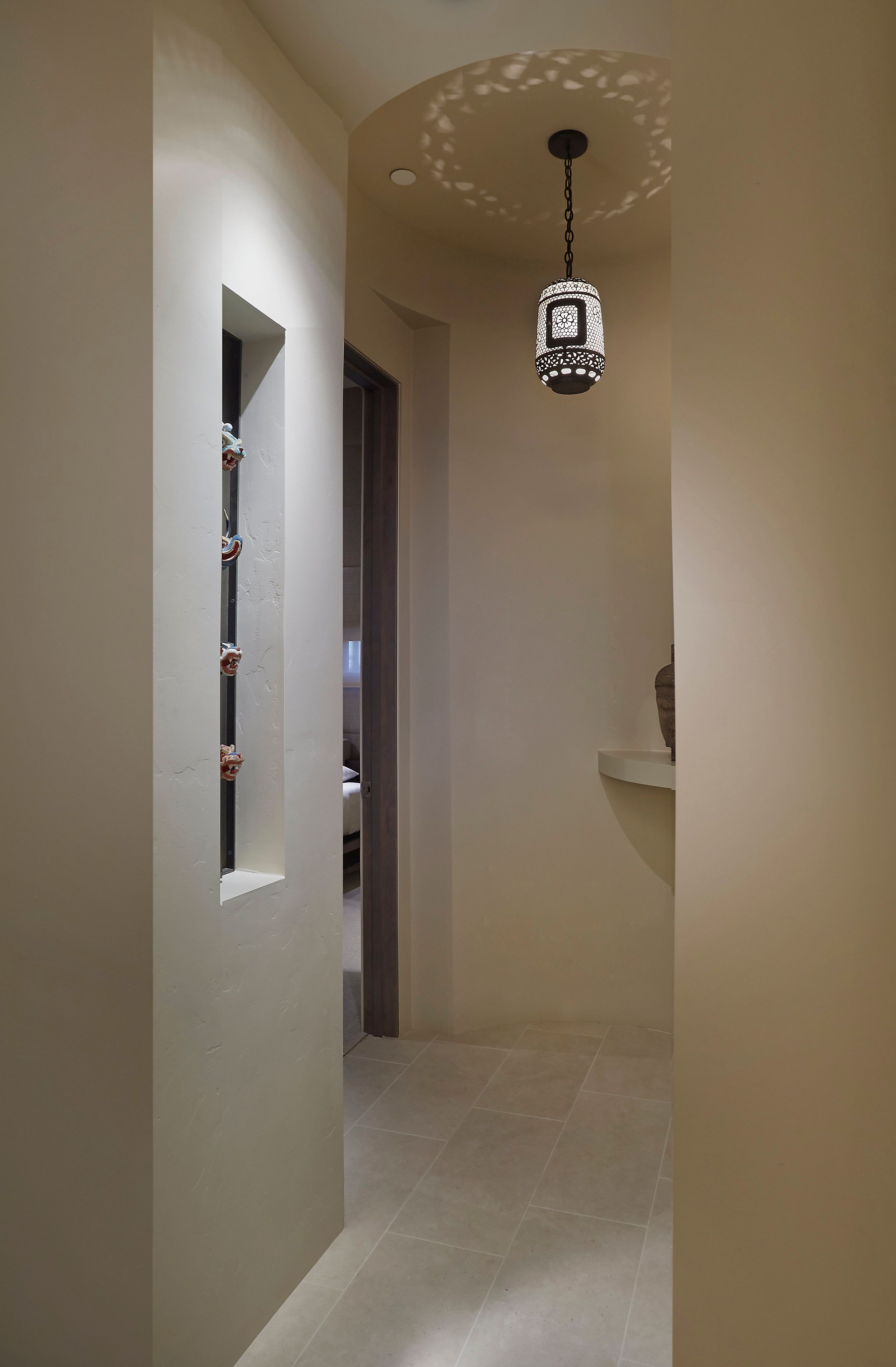 Hallway with slot windows, a pendant lantern and plaster walls