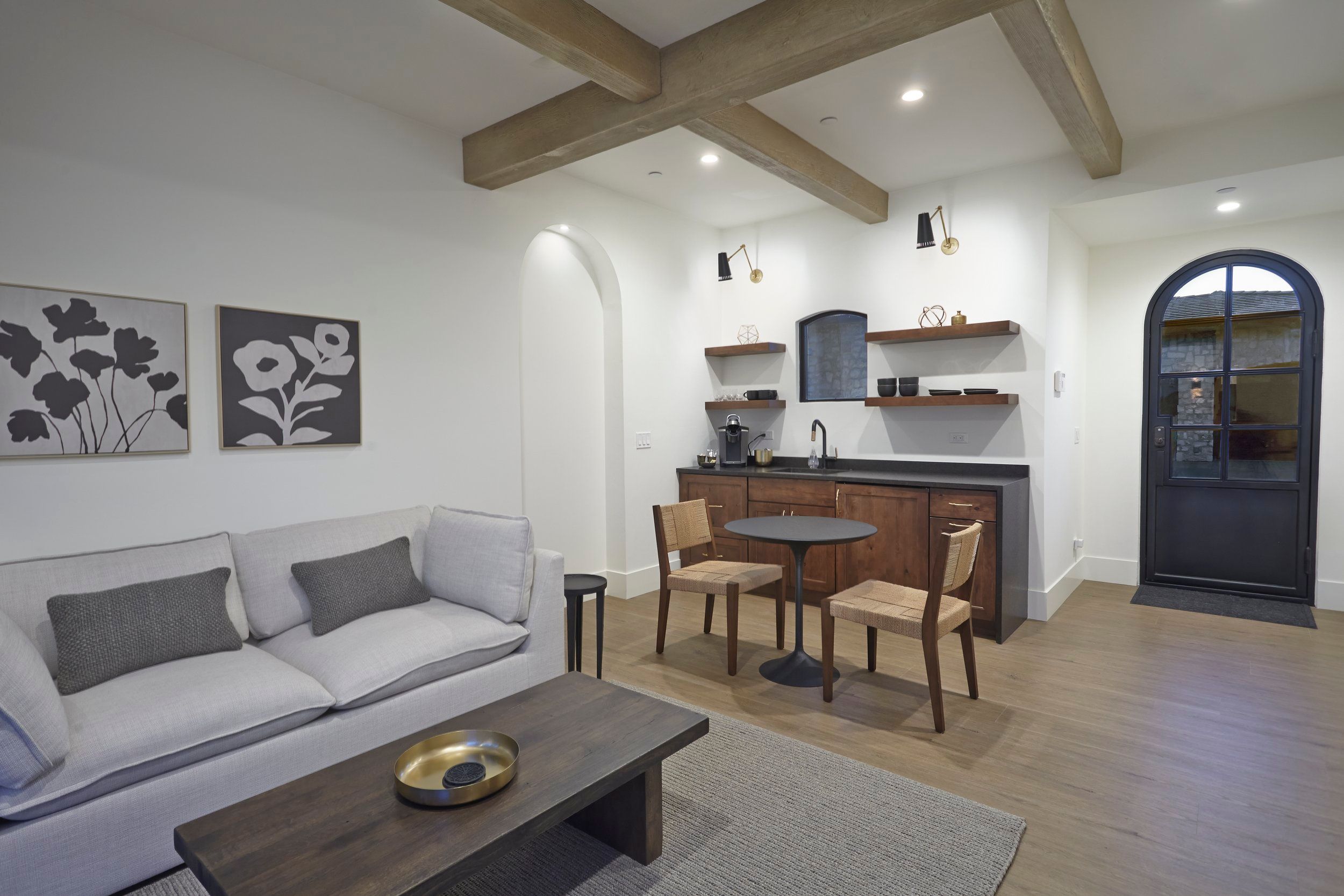 Casita sitting room with a kitchenette, beamed ceiling and arched door