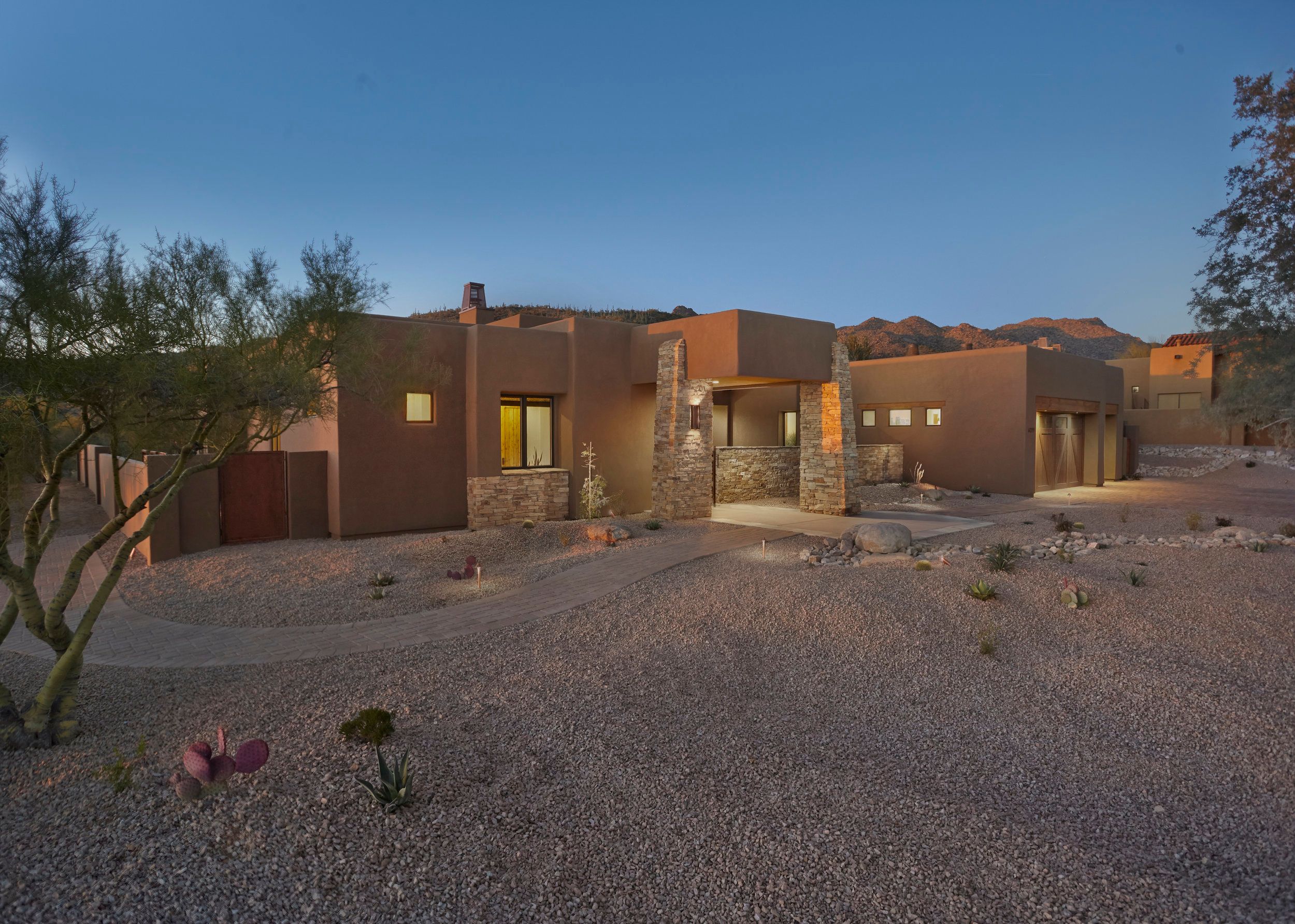 Front elevation at dusk with stone accents and desert gravel landscaping