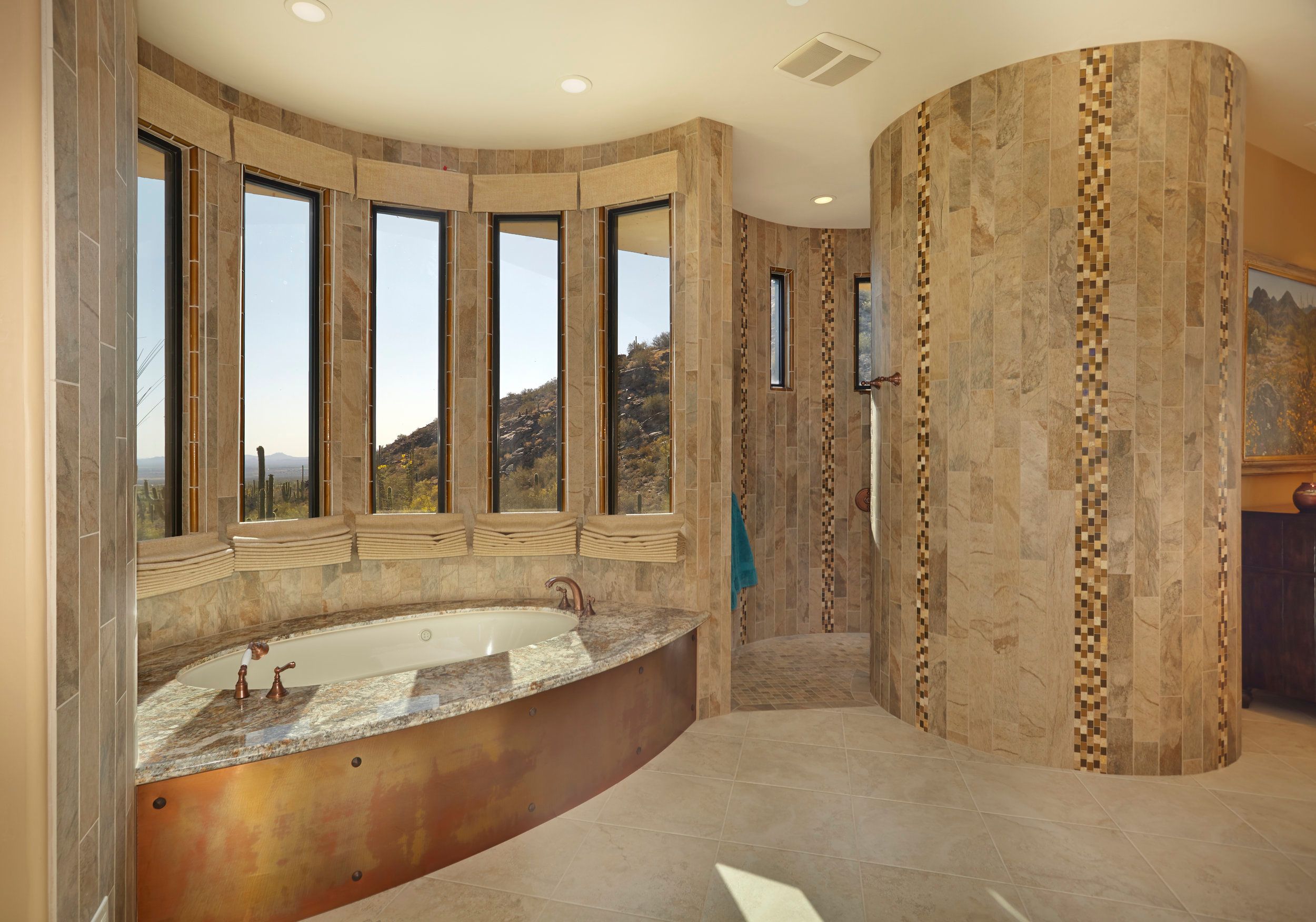 Primary bathroom with a curved travertine shower and tub beneath a window bay