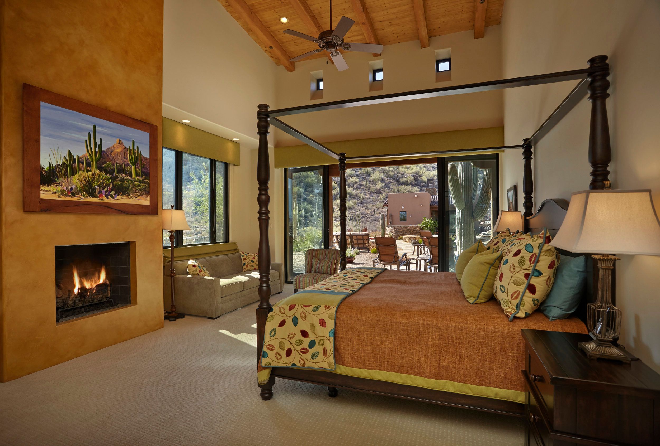 Primary bedroom with a four-poster bed, corner fireplace and doors to the patio