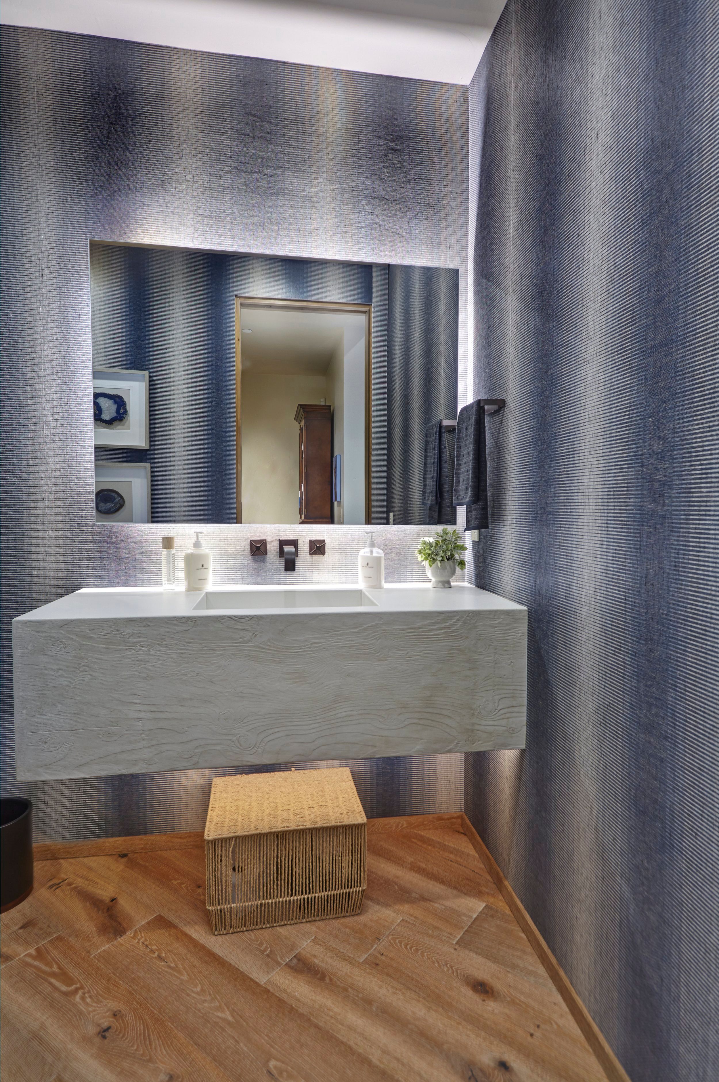 Powder room with a floating concrete vanity and textured grasscloth walls
