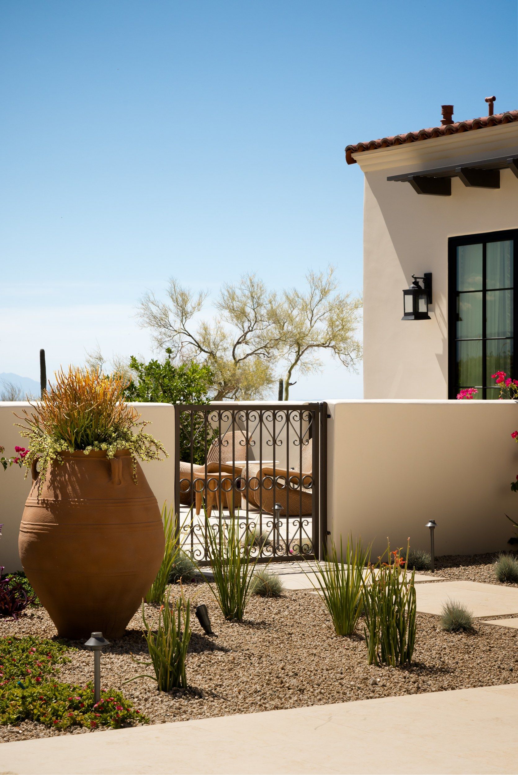 Entry gate with a large terracotta urn and ocotillo planting
