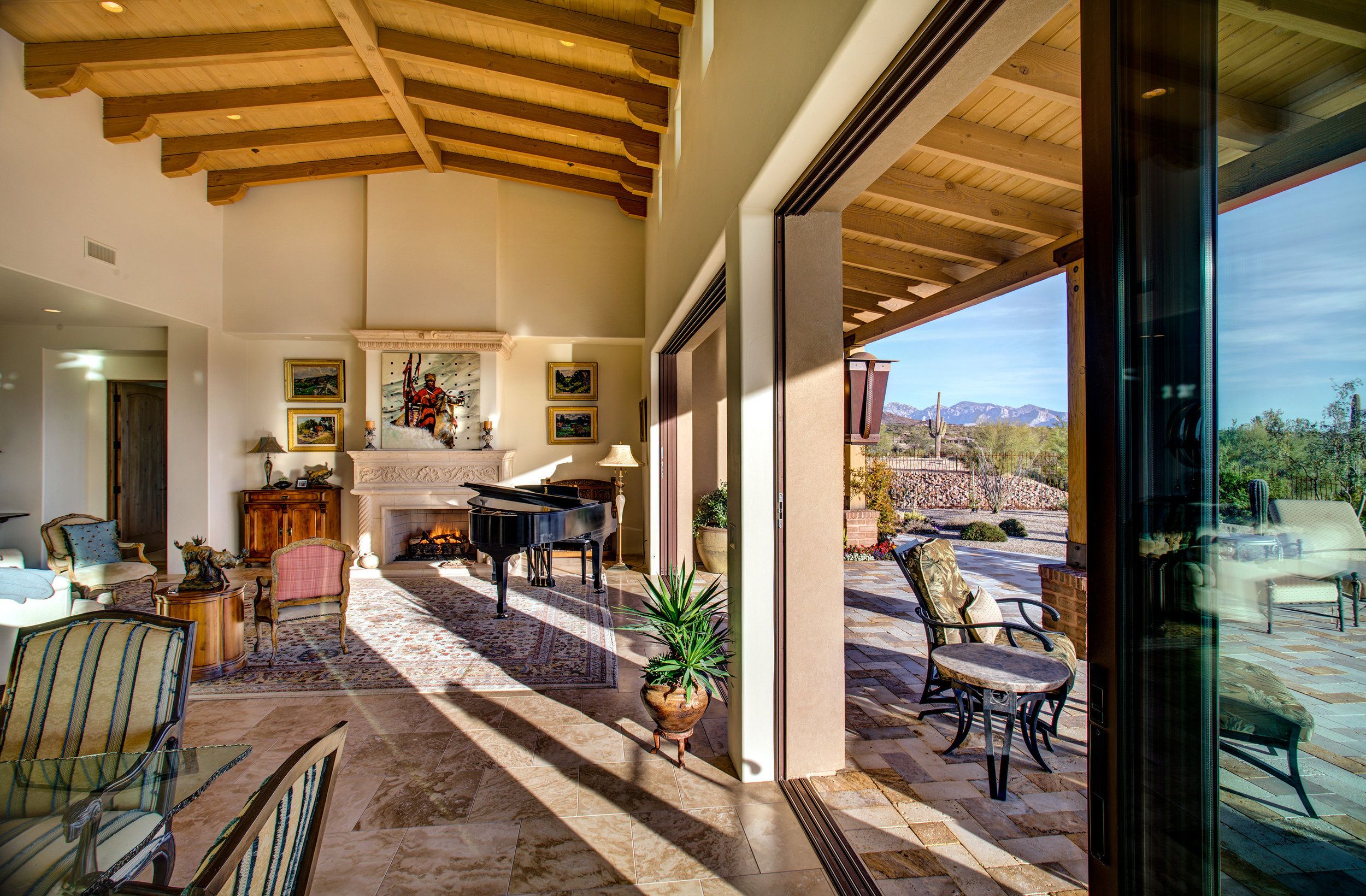 Great room looking toward a retracted glass wall opening to the covered patio and desert