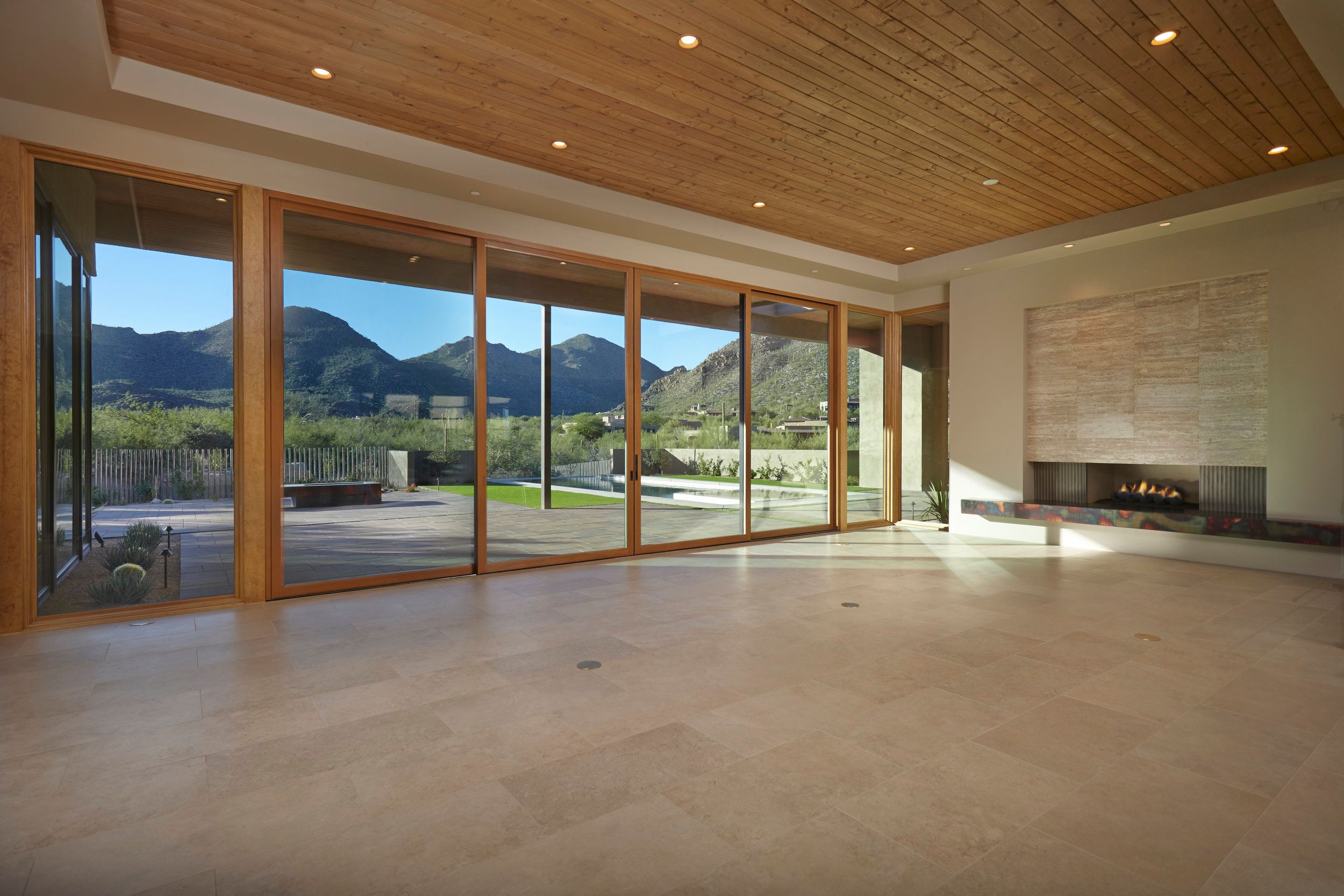Living room with a linear fireplace and full-height glass onto the mountain view