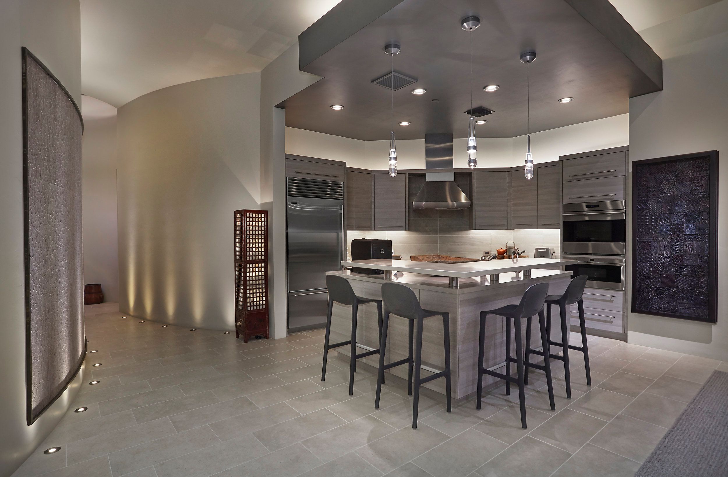 Contemporary kitchen with a stainless island, bar seating and curved partition wall