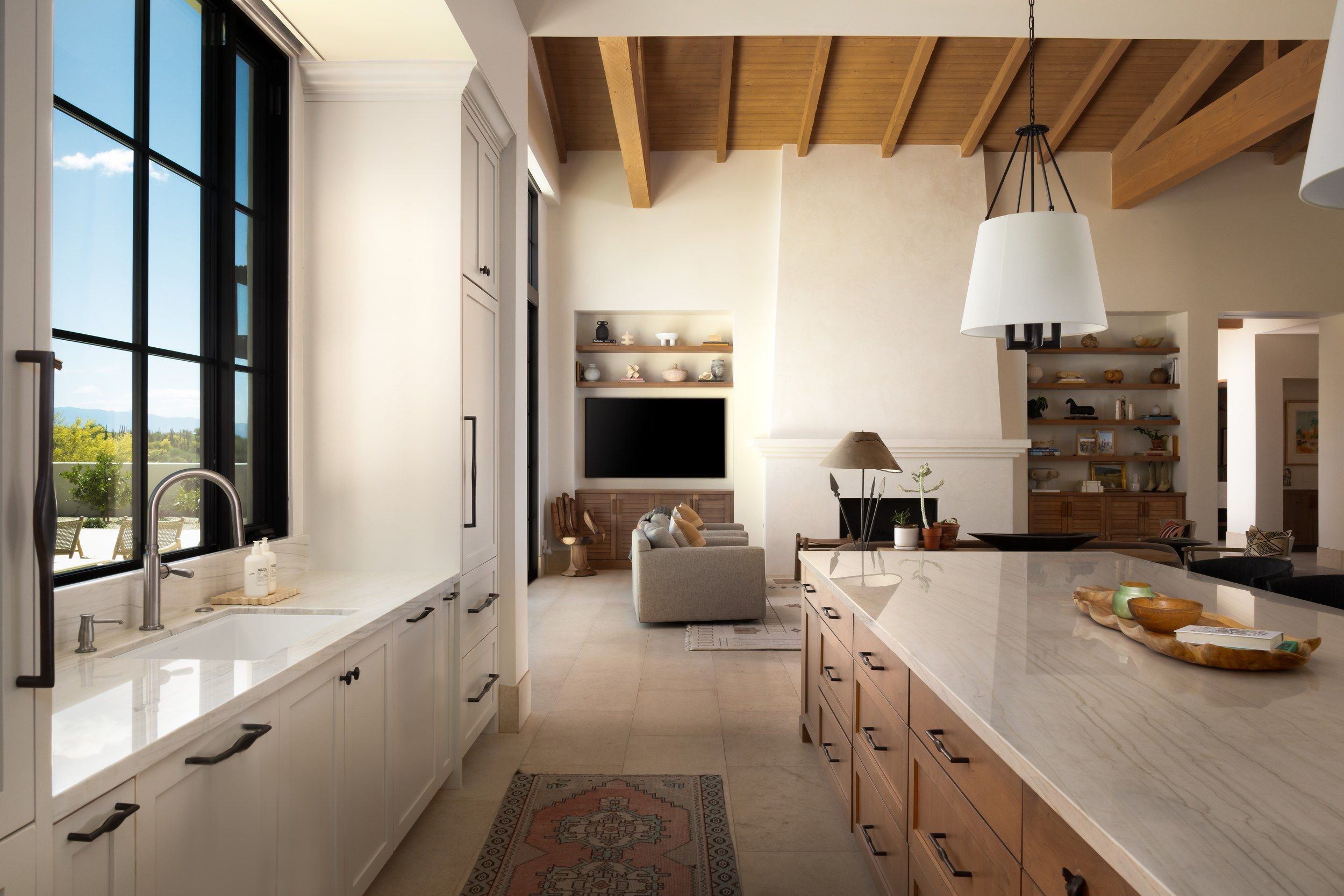Kitchen with a beamed ceiling, marble island and steel-framed windows