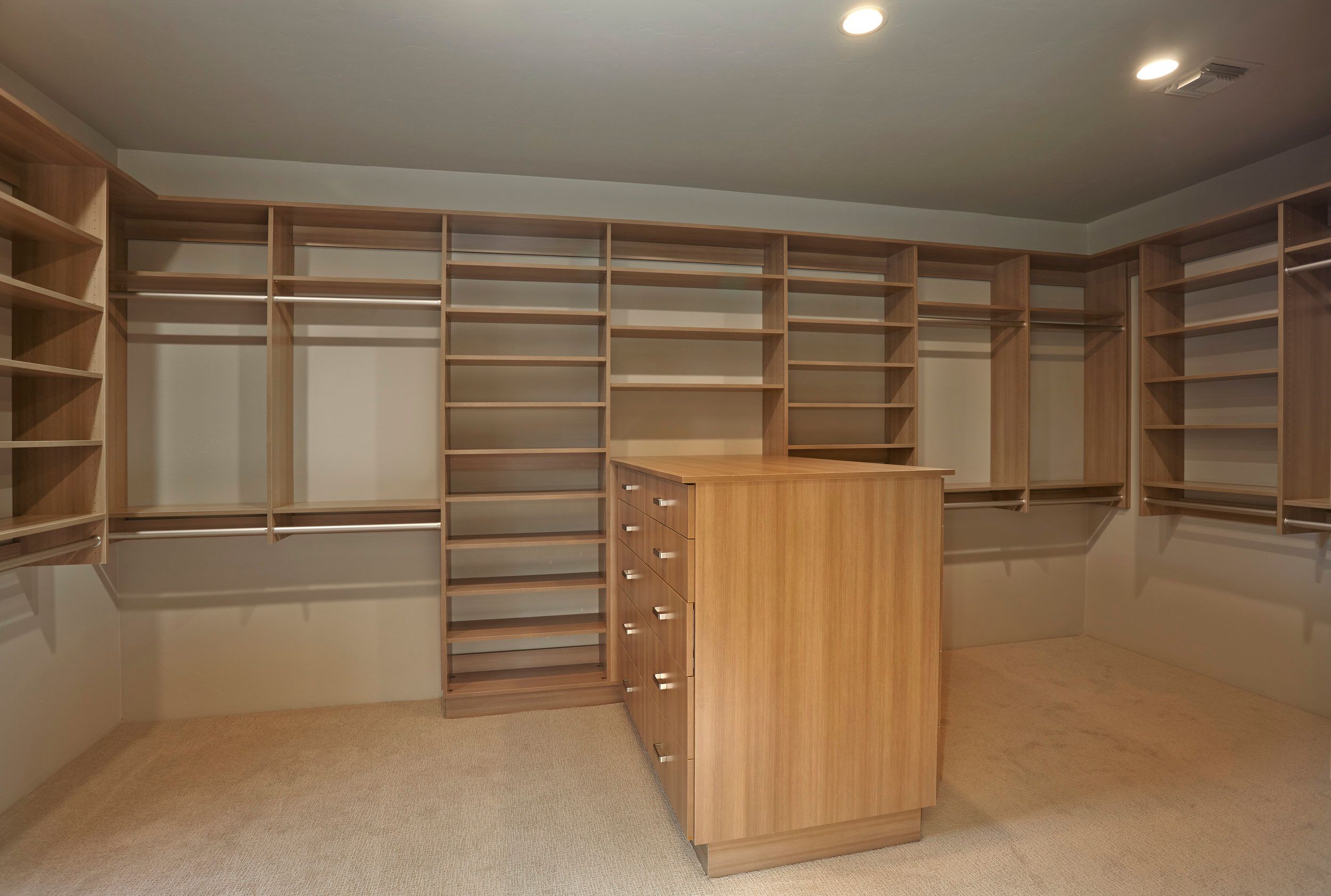 Walk-in closet with floor-to-ceiling built-in shelving and a centre island