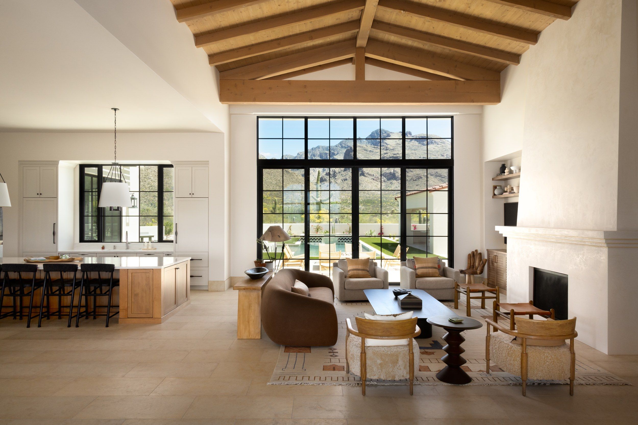 Great room with a beamed ceiling, fireplace and the kitchen beyond