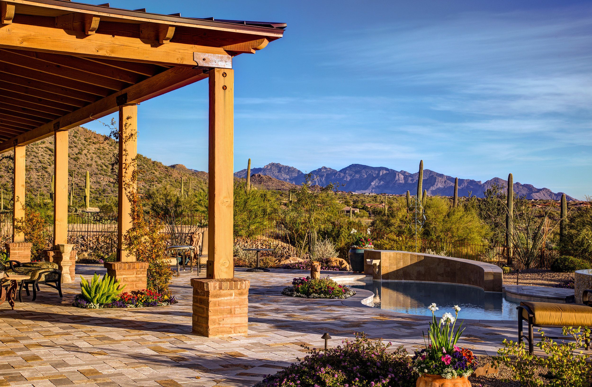 Timber ramada beside the pool looking out to saguaros and the Tortolita Mountains