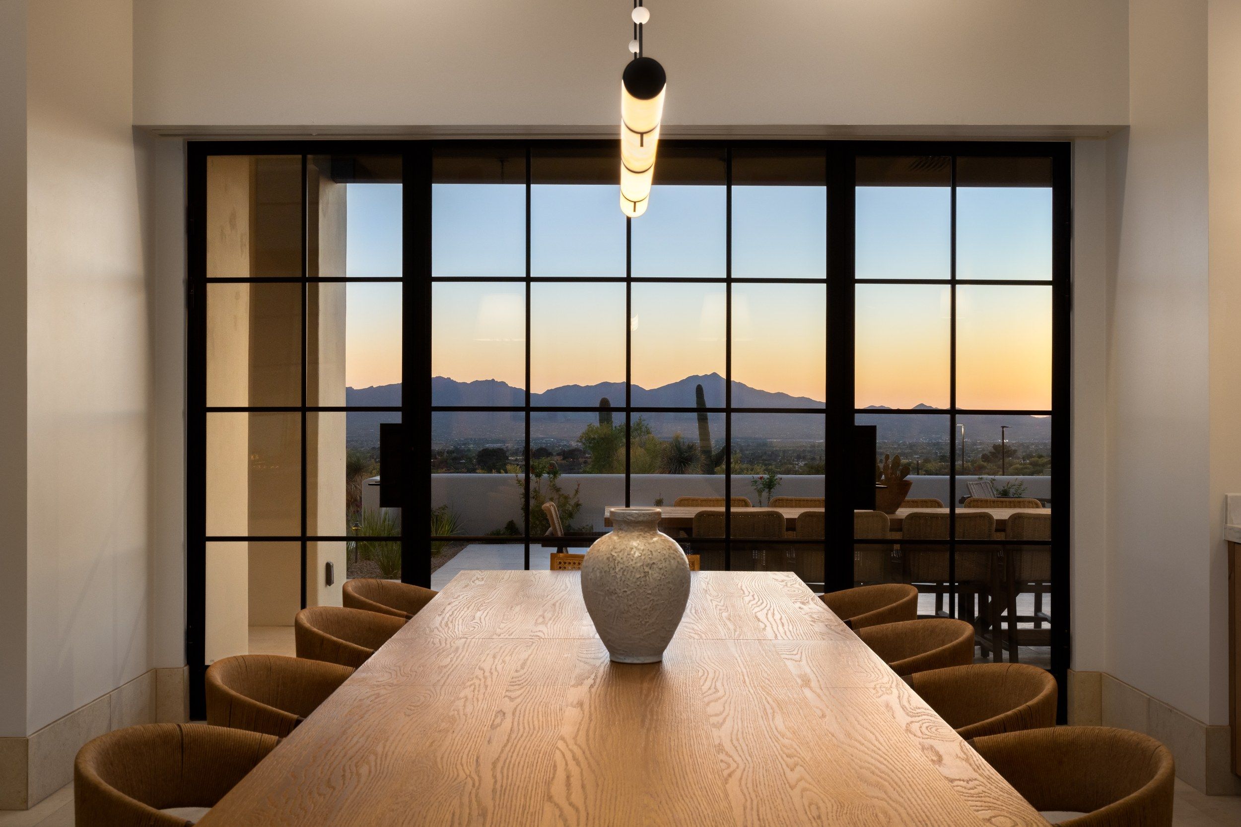 Dining table at sunset with the valley through a wall of steel windows